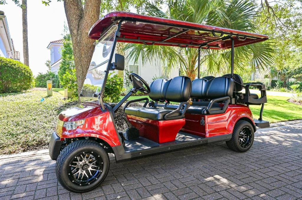 a red golf cart parked on a sidewalk at Tivoli 5292 in Destin