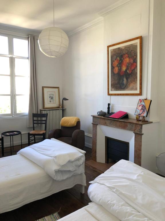 a room with two beds and a fireplace at Beautifully renovated rooms on Place New York in Angoulême