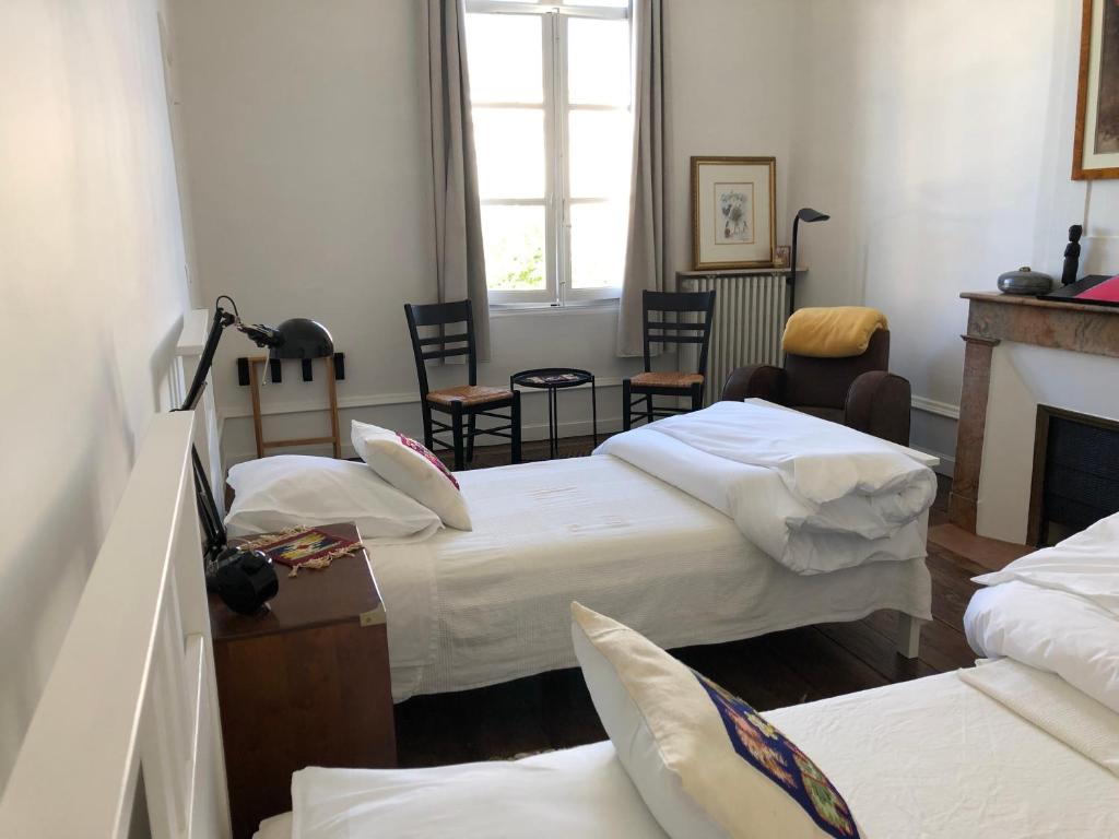 a room with three beds and a fireplace at Beautifully renovated rooms on Place New York in Angoulême
