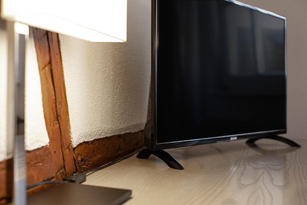 a computer monitor sitting on a desk next to a lamp at Hotel am Jakobsmarkt in Nuremberg