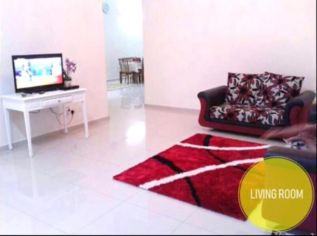 a living room with a couch and a table with a television at Hani Guest House Big House in Malacca