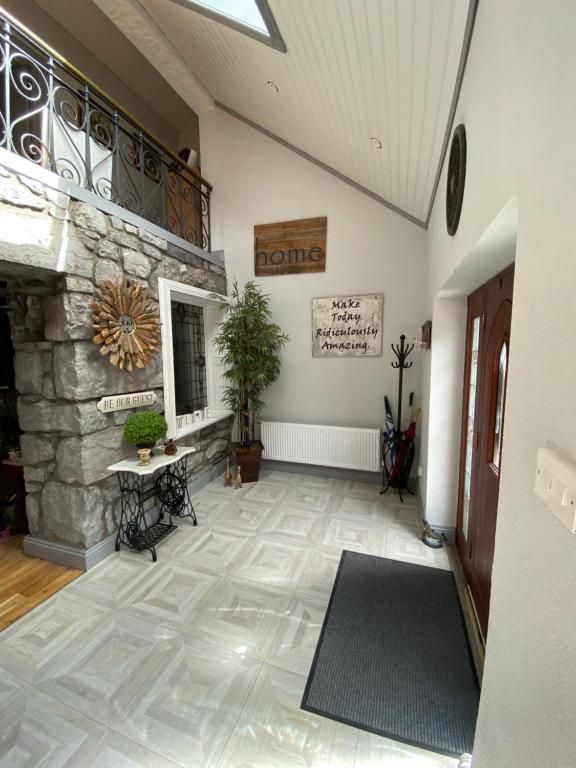 a living room with a stone fireplace and a hallway at Salmon Weir Lodge in Cong