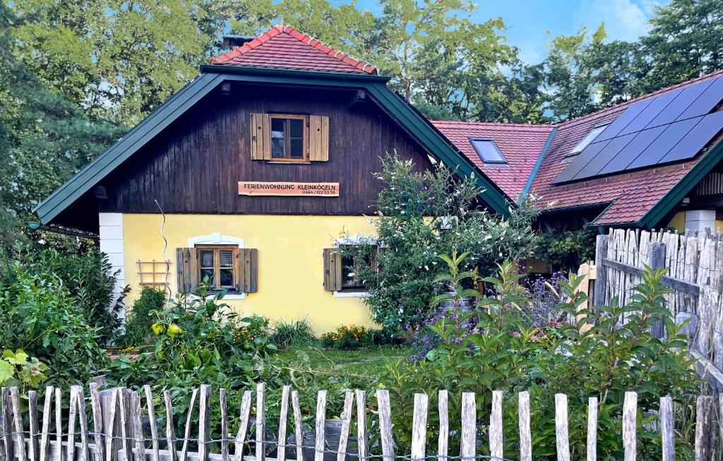 une maison avec des panneaux solaires sur le toit et une clôture dans l'établissement Ferienwohnung Kleinkögeln, 