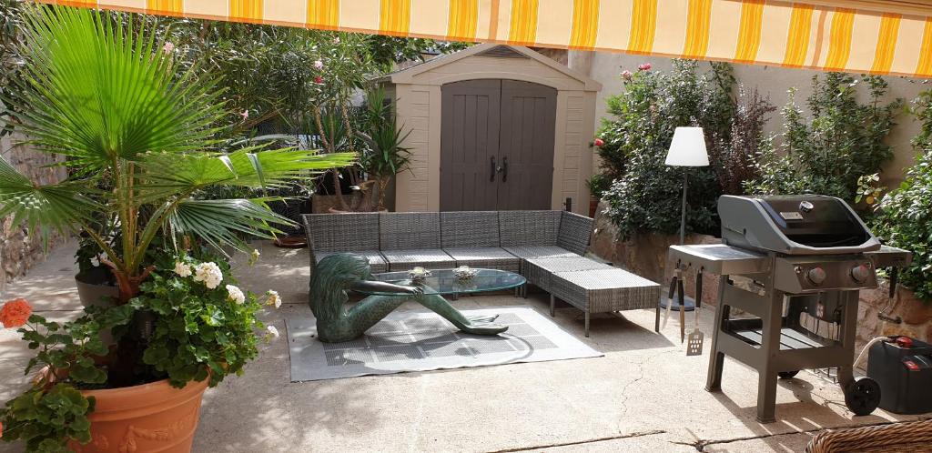 a patio with a bench and a fountain and a grill at Chez Laurette à Bergheim in Bergheim