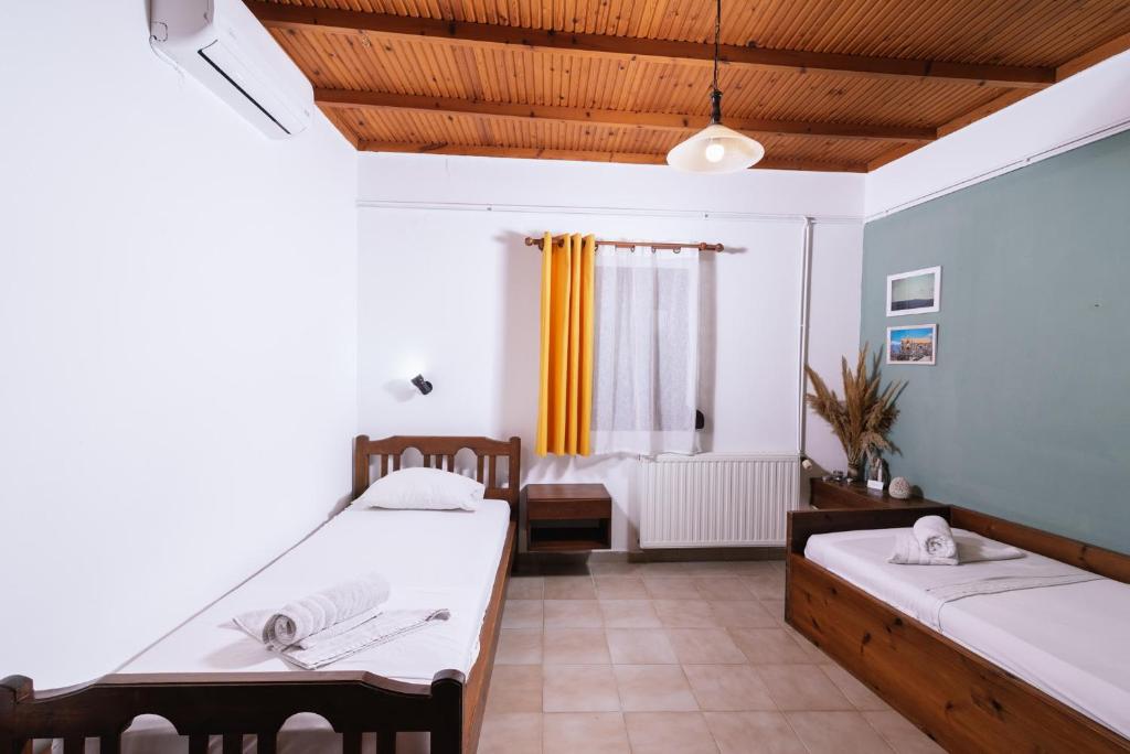 sala de estar con 2 camas y ventana en OVGORA - Aretousa sea view room, Kamilari village, en Kamilari