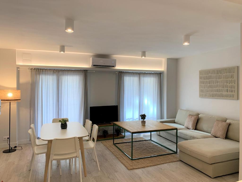 uma sala de estar com um sofá e uma mesa em Apartamento nuevo, 3 dormitorios con terraza em Granada