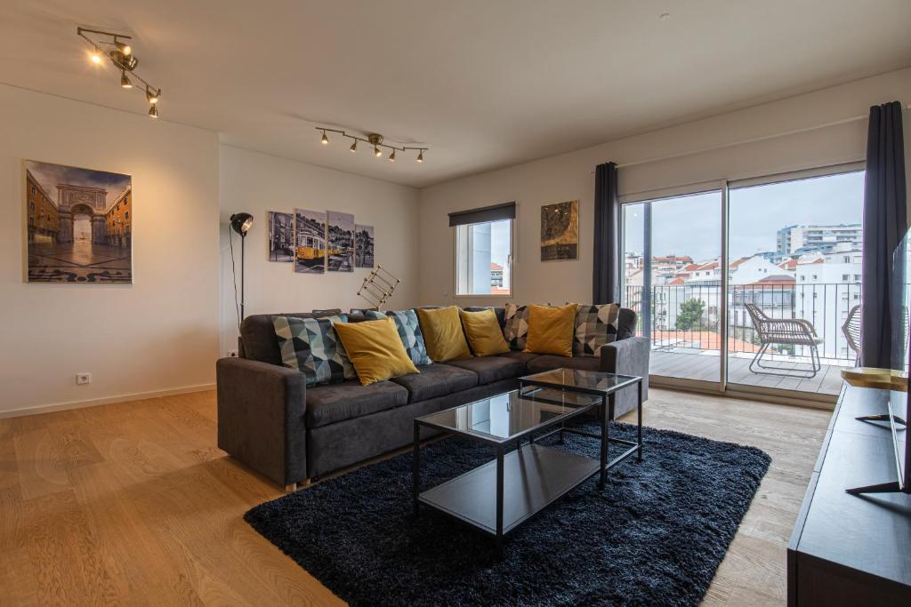 ein Wohnzimmer mit einem Sofa und einem Glastisch in der Unterkunft Saldanha Flats I by Innkeeper in Lissabon