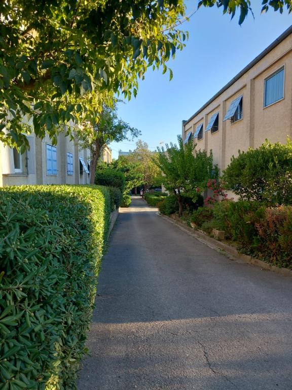 eine Straße mit Hecke vor einem Gebäude in der Unterkunft Appartement/studio dans petite résidence calme in La Ciotat