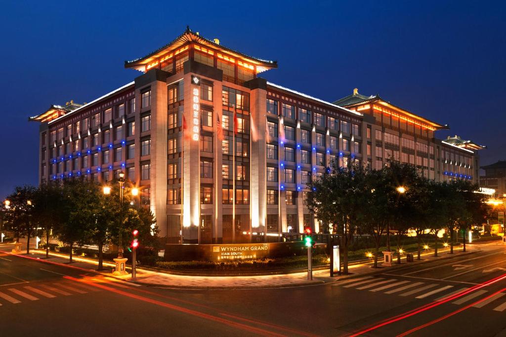 un gran edificio con luces encendidas por la noche en Wyndham Grand Xi'an South, en Xi'an