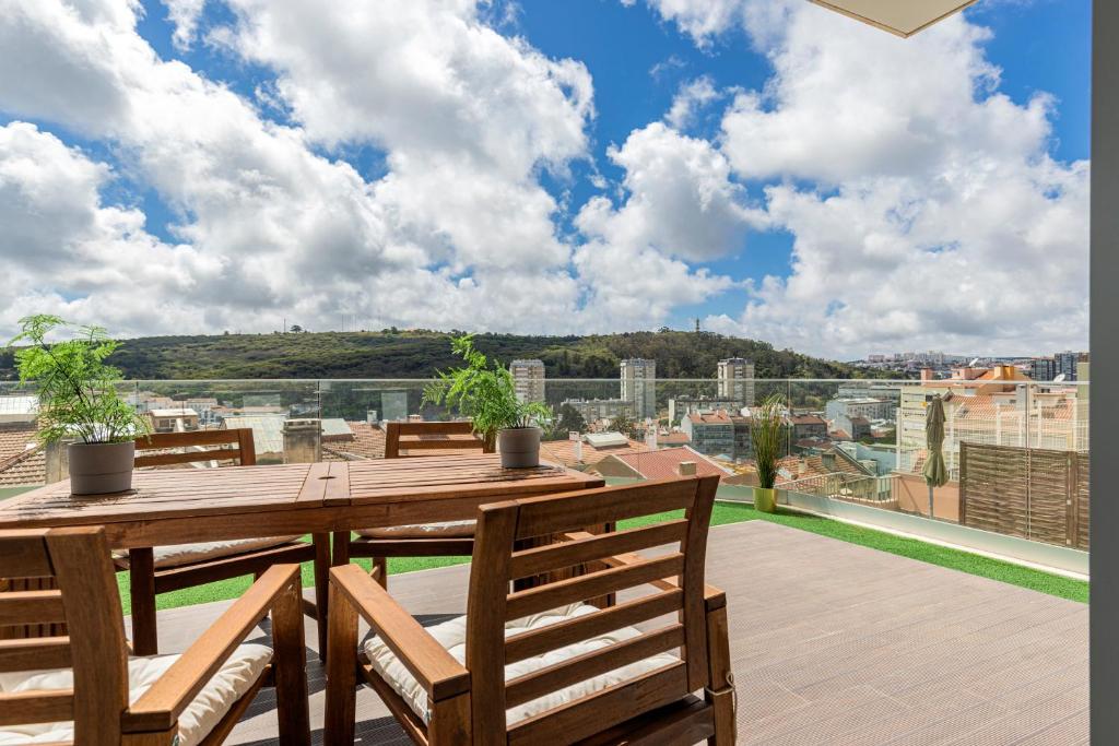 里斯本的住宿－Fabulous Terrace over Monsanto by Innkeeper，观景阳台配有一张木桌和椅子。