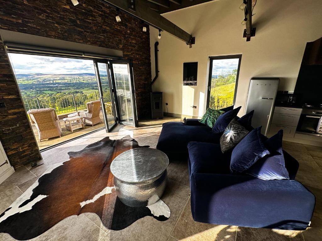 a living room with two couches and a table at The Chicken Shed at Knowle Top in Clitheroe