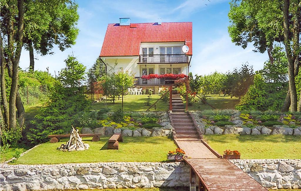 a house with a red roof in a garden at Awesome Home In Dzwierzuty With 3 Bedrooms And Wifi in Dźwierzuty