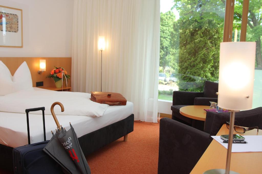 a hotel room with a bed and a couch and a table at Hotel Don Bosco in Aschau am Inn