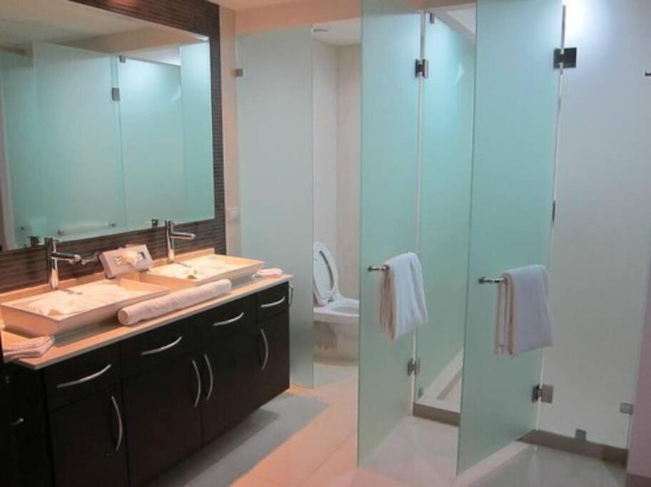 a bathroom with a sink and a shower with a mirror at Condo/ Depa - Marea Azul - Playa del Carmen in Playa del Carmen