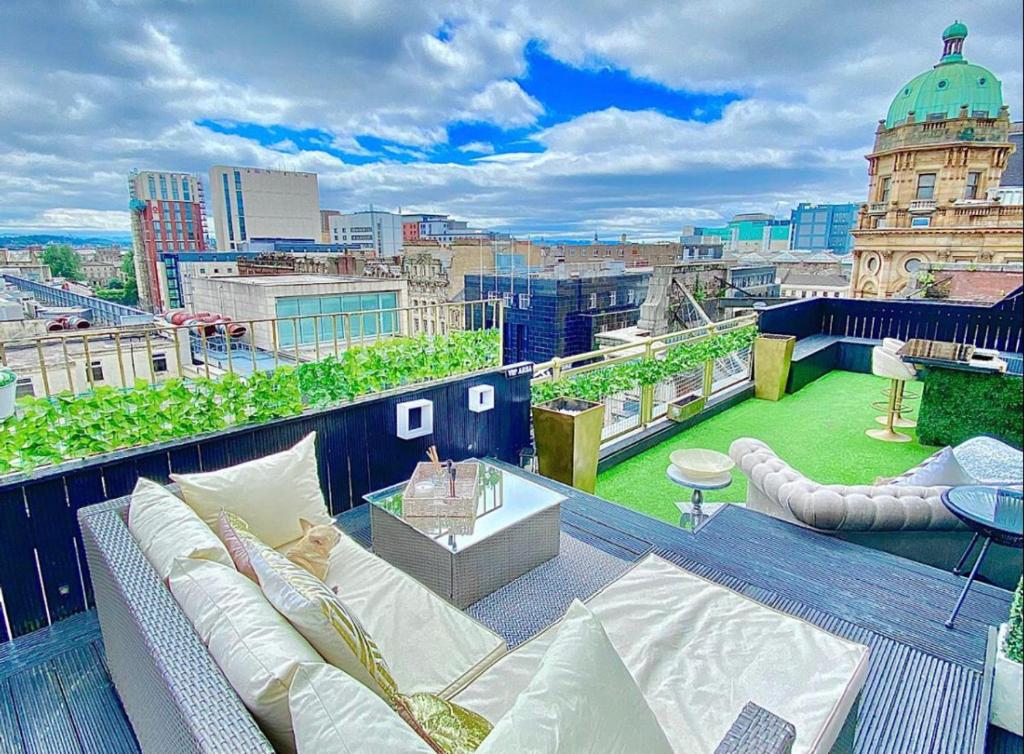 a balcony with a couch and a view of a city at Glasgow two bedroom Penthouse in Glasgow