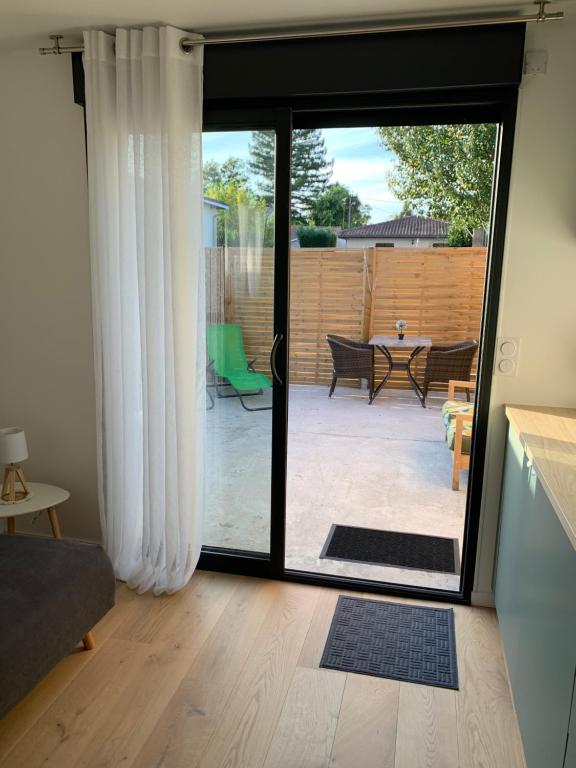 a living room with a door open to a patio at Studio La Petite Forge in Castelnau-de-Médoc