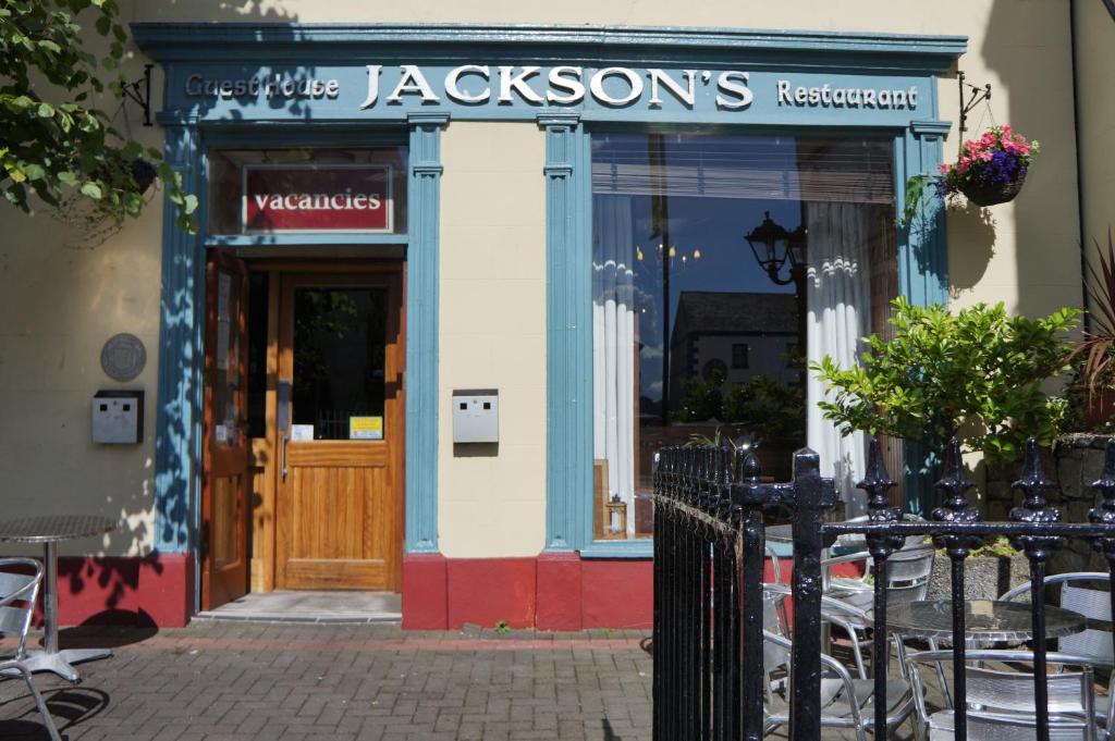 uma loja em frente a um restaurante com uma porta de madeira em Jacksons Restaurant and Accommodation em Roscommon