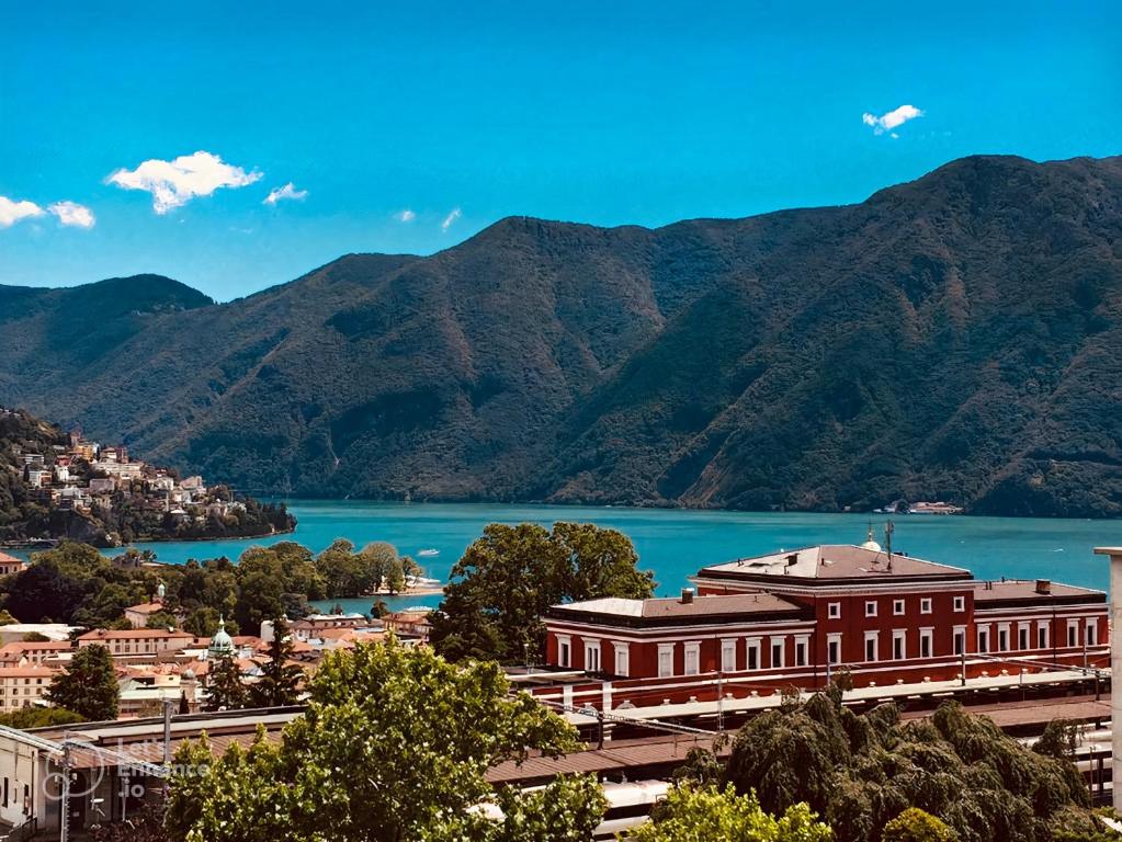 Blick auf ein großes Gebäude mit Bergen im Hintergrund in der Unterkunft Lakeview Panorama Penthouse with Washer & Dryer in Lugano