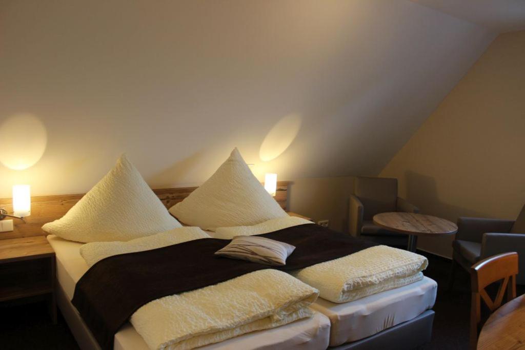 ein Schlafzimmer mit einem Bett mit Kissen darauf in der Unterkunft Gasthof Klosterkeller in Kronach