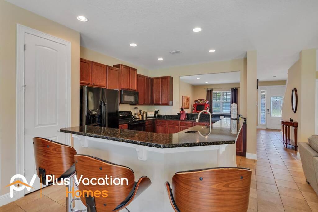 a kitchen with a counter and some wooden cabinets at 371-Luxury Villa with POOL in Orlando