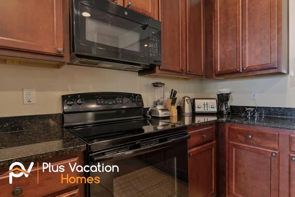 a kitchen with a stove and a microwave at 371-Luxury Villa with POOL in Orlando