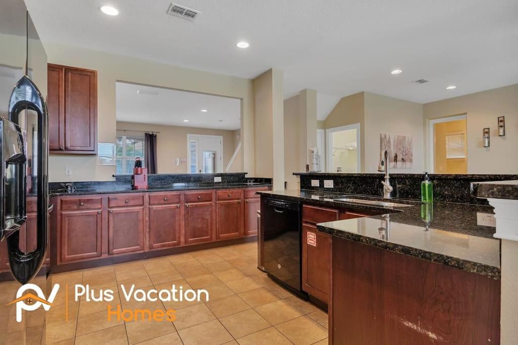 a large kitchen with wooden cabinets and appliances at 371-Luxury Villa with POOL in Orlando