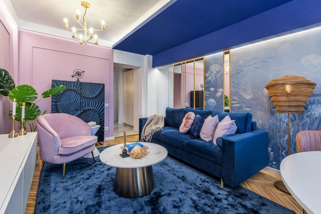 sala de estar con sofá azul y mesa en HOLT - Jules Verne's Imaginarium, en Bucarest