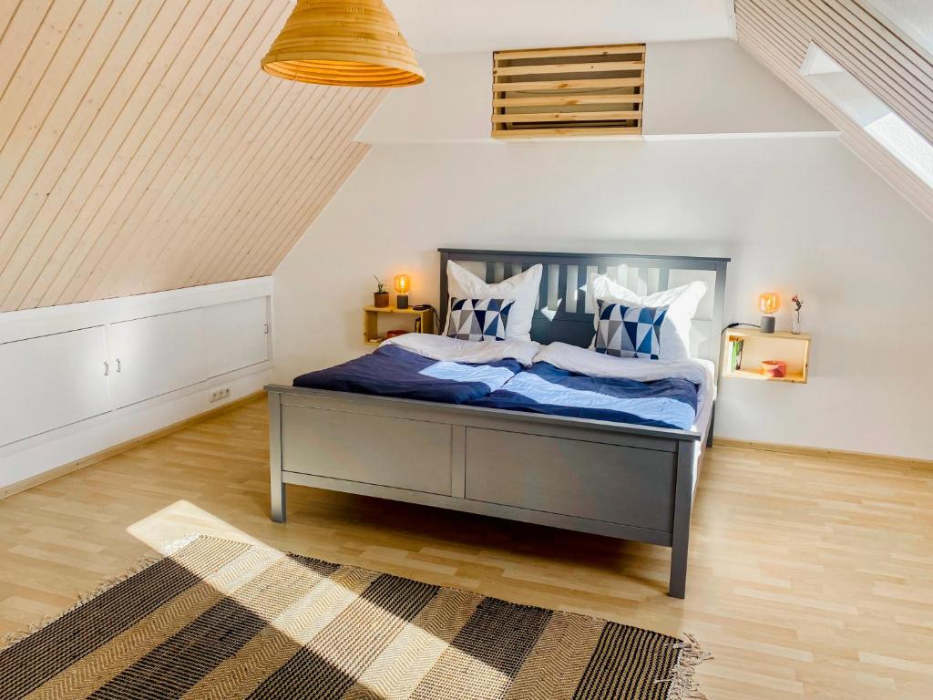 Schlafzimmer mit einem Bett mit blauer Bettwäsche und Kissen in der Unterkunft Zwischen Wolfsburg, Tankumsee und Ilkerbruch - Apartment im Boldecker Land in Osloß