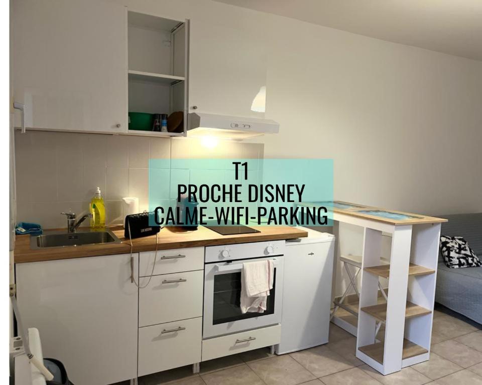 een witte keuken met een bord dat zegt tru proctor oprit game parking wifi bij Superbe studio proche Disney in Champs-Sur-Marne