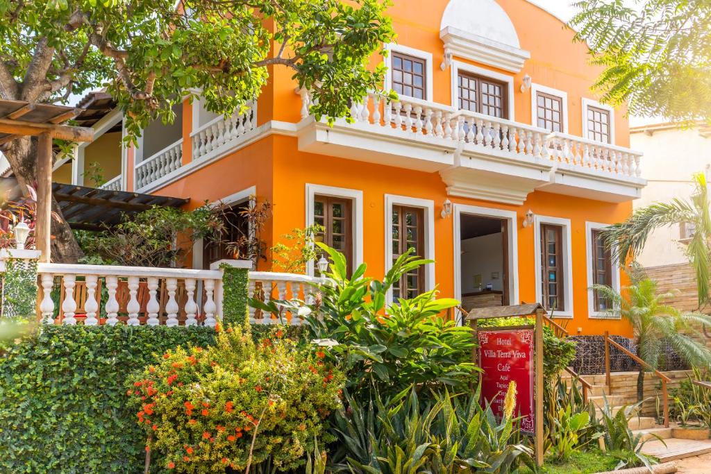 ein orangefarbenes Haus mit einem weißen Balkon in der Unterkunft Hotel Villa Terra Viva in Jericoacoara