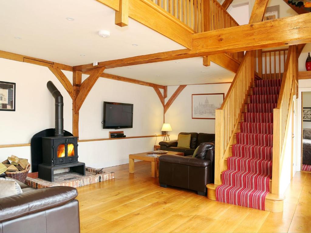 a living room with a wood stove and a couch at The Hayloft in Chislet