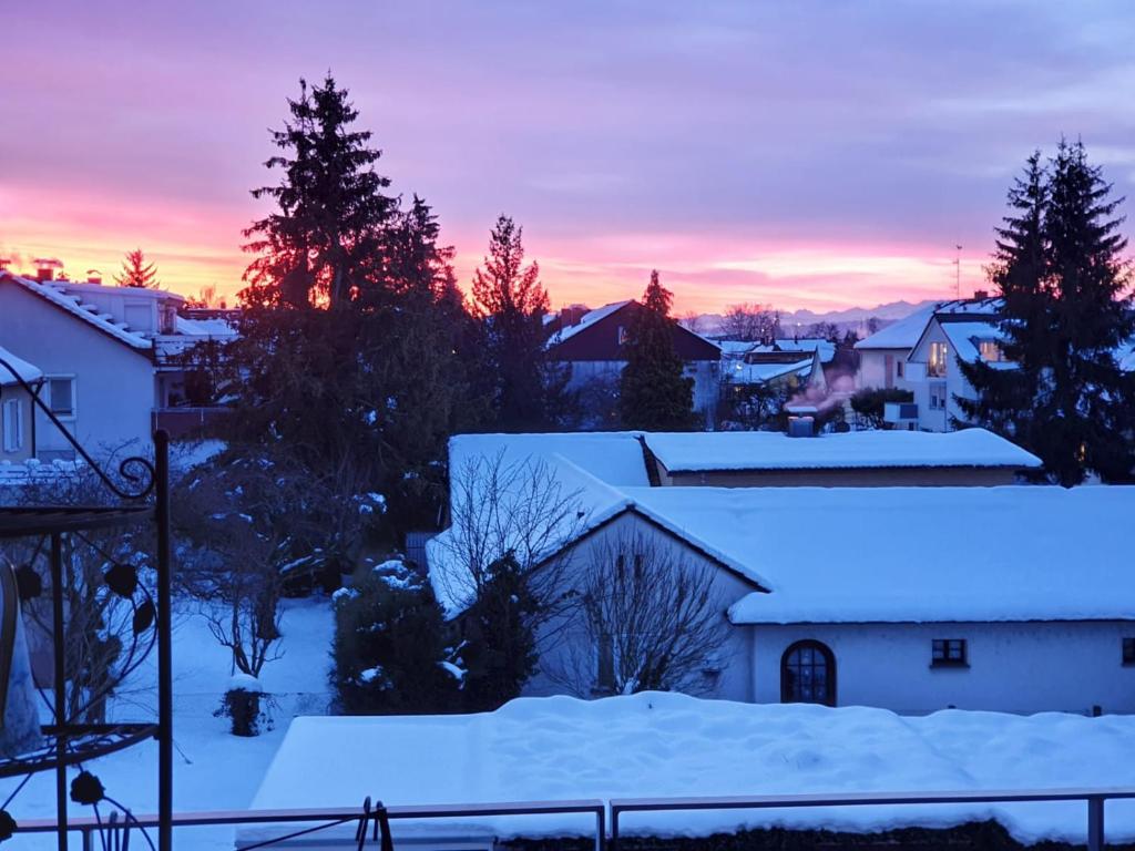 una puesta de sol invernal sobre una ciudad con nieve tejados cubiertos en Wohnung im Schwarzwald mit Panorama Blick en Kleines Wiesental
