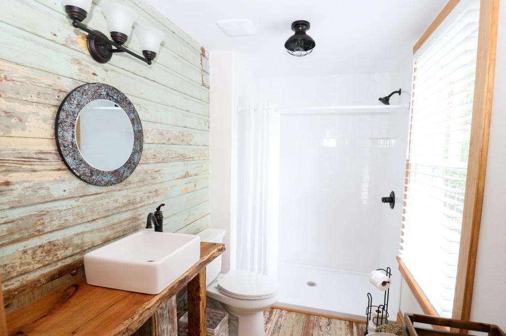 bagno con lavandino bianco e specchio di Sweetwater Branch Inn a Gainesville