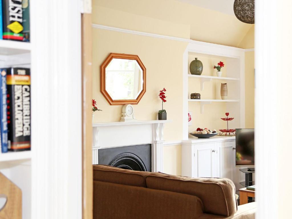 a living room with a couch and a mirror at Hamilton House in Royal Tunbridge Wells