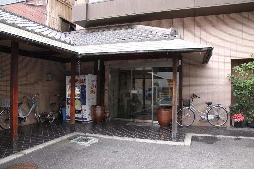 twee fietsen staan geparkeerd buiten een gebouw bij Osaka Ryokan Kuramoto in Osaka