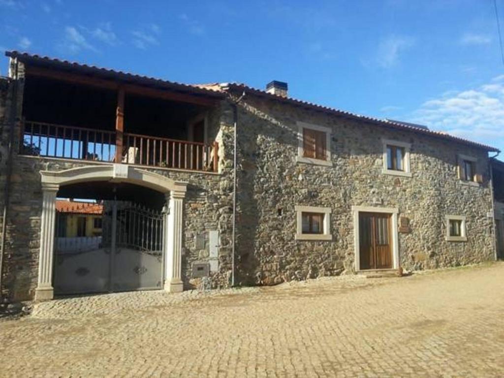 un gran edificio de piedra con balcón. en Moleiro de Bacal, en Baçal