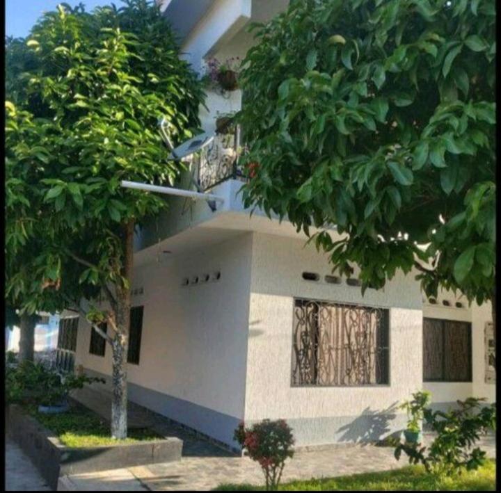 a white house with trees in front of it at Casa de descanso in Mariquita