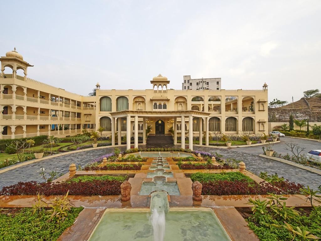 a large building with a fountain in front of it at Club Mahindra Udaipur in Udaipur