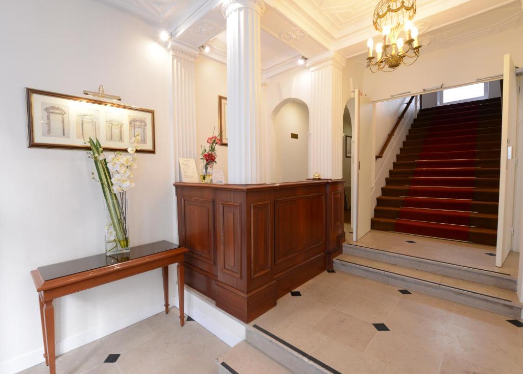 a lobby with a staircase and a stair case at Hotel Imperial Paris in Paris