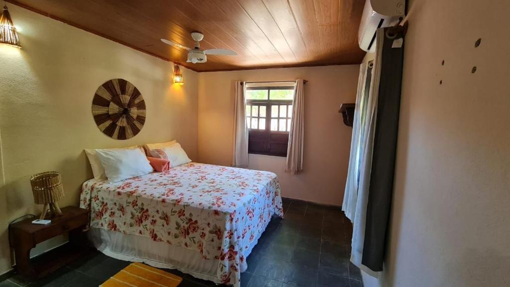 um pequeno quarto com uma cama e uma janela em Villa da Barca na Ilha de Boipeba