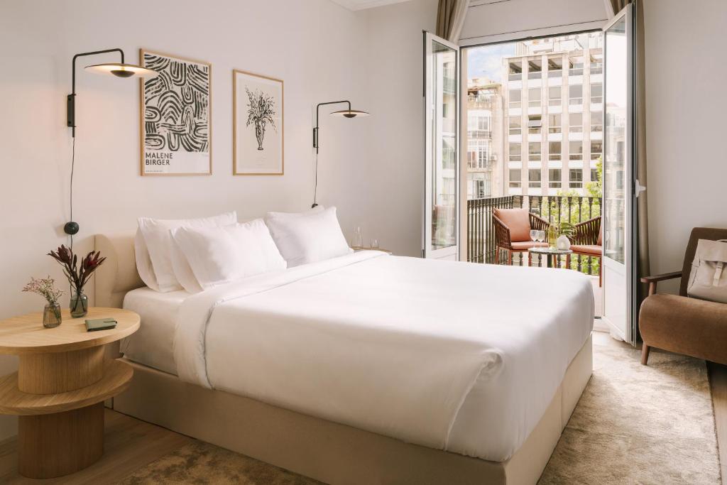 - une chambre avec un grand lit blanc et un balcon dans l'établissement Sonder Paseo de Gracia, à Barcelone