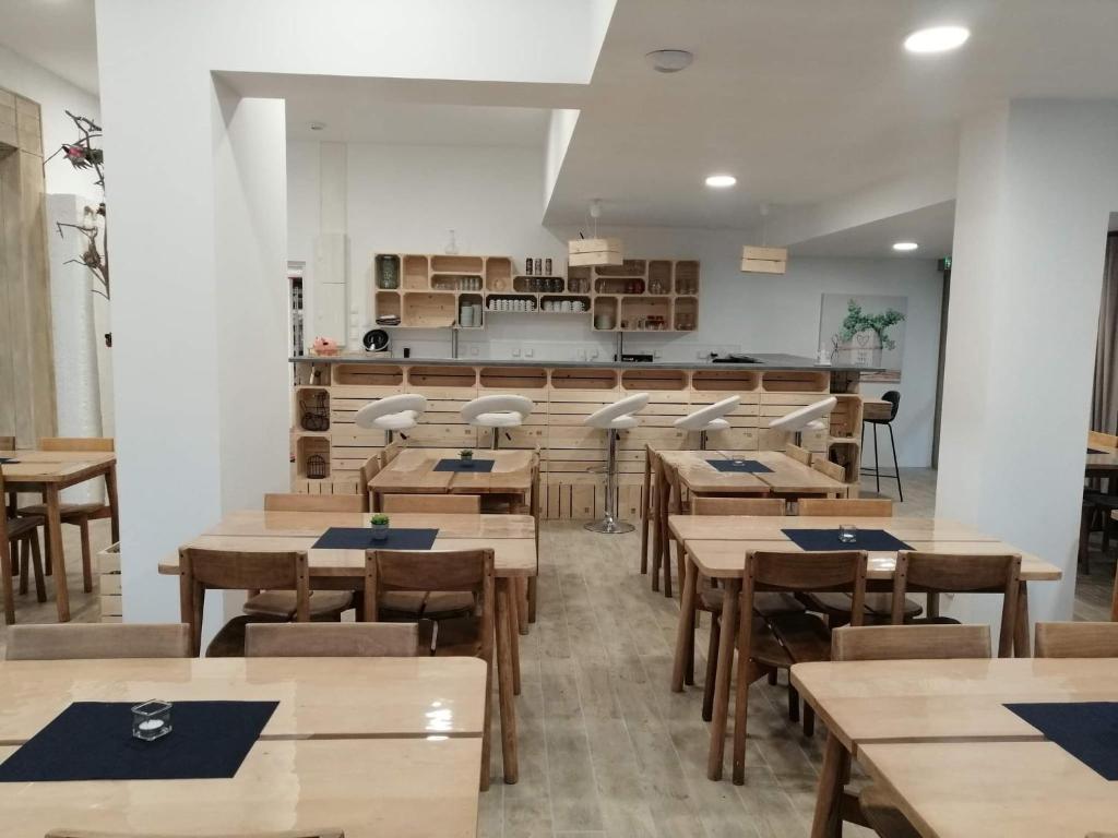 an empty restaurant with wooden tables and chairs at Village Bord de Ciel in Caylus