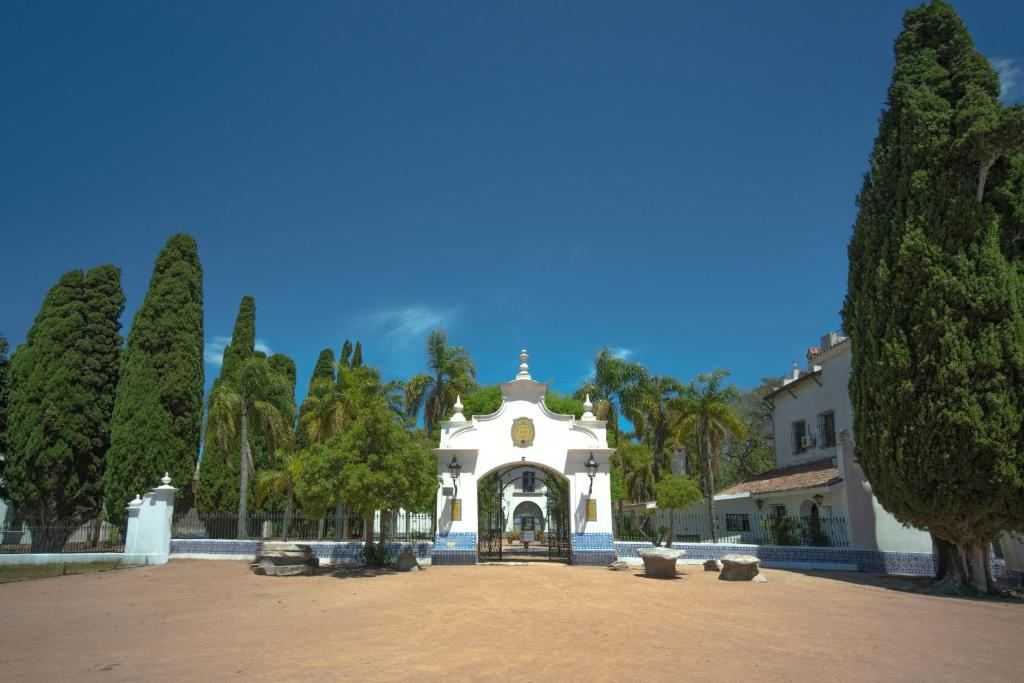 a large white building with a gate in a park at Estancia Turística San Pedro de Timote in Reboledo