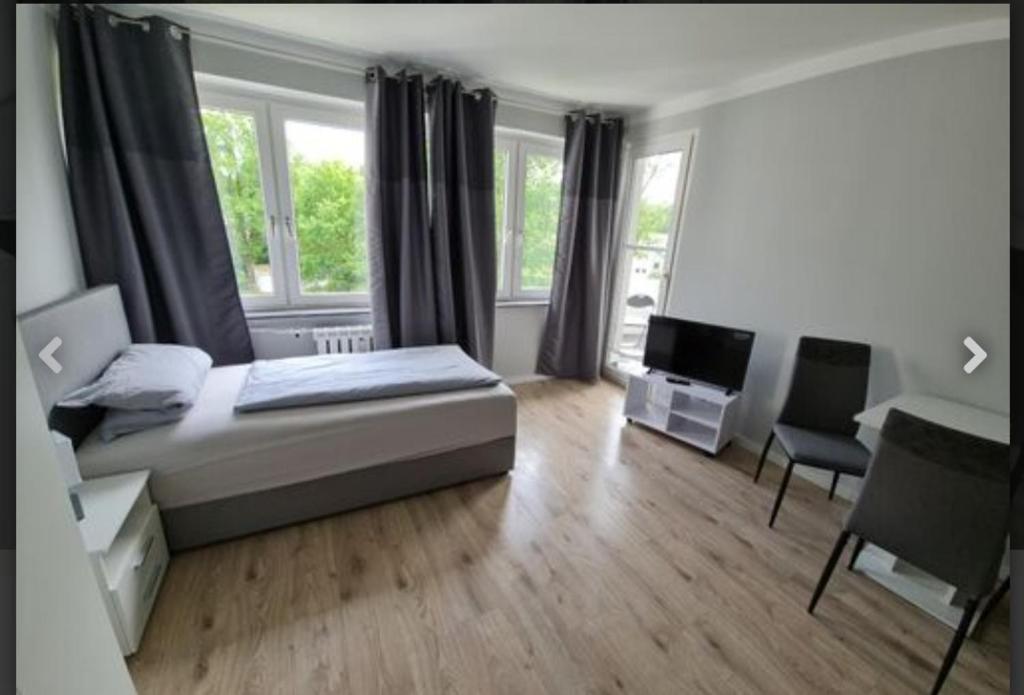 um quarto com uma cama, uma secretária e uma janela em Schönes neuwertiges 3 Zimmer Apartment - zentral em Wolfsburg