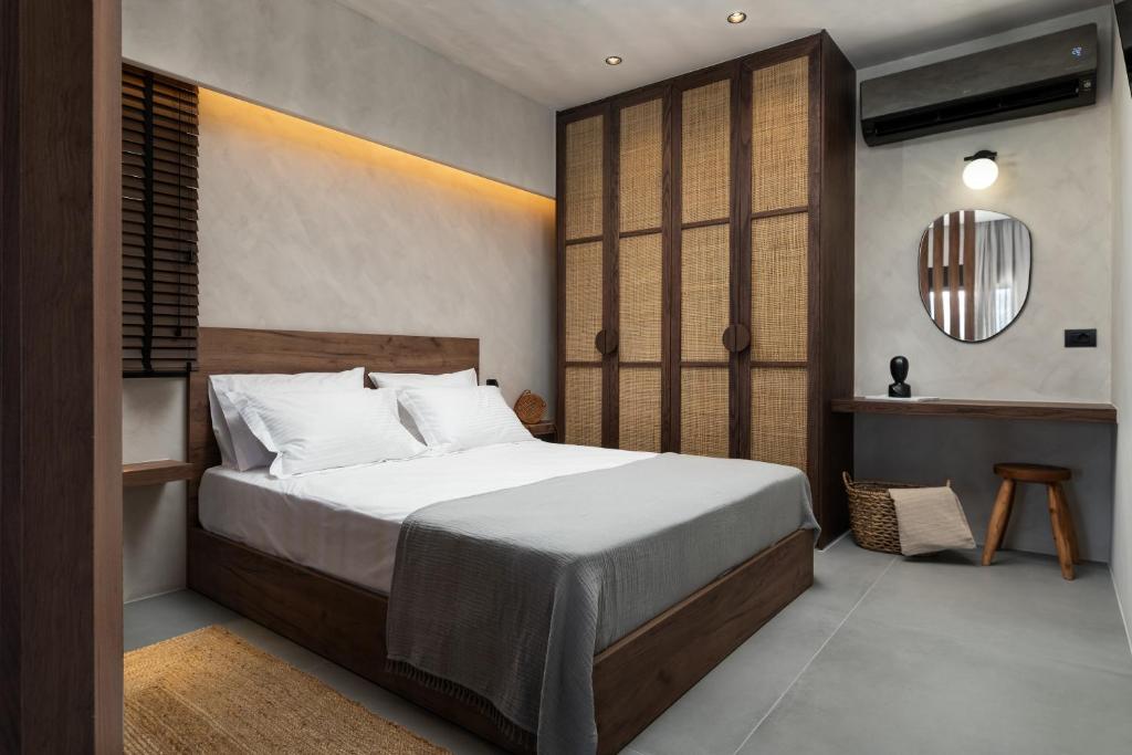 una camera da letto con un letto grande e uno specchio di KOEV slow living a Tsikalariá