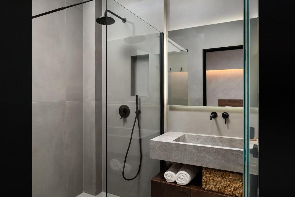 bagno con doccia, lavandino e specchio di KOEV slow living a Tsikalariá