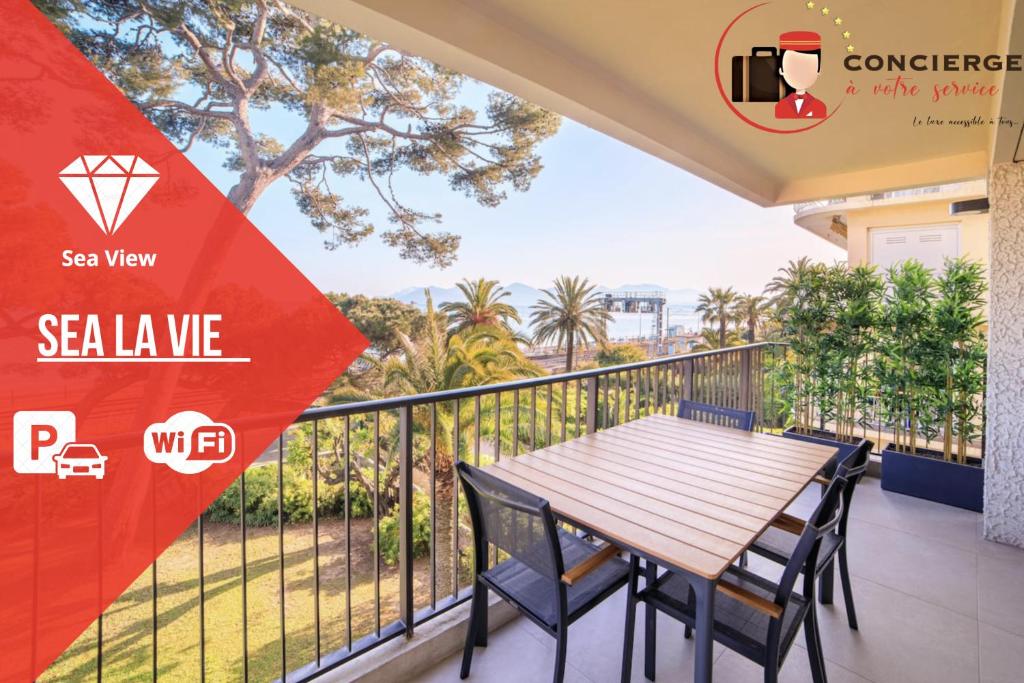 einen Balkon mit einem Holztisch und Stühlen in der Unterkunft "Sea La Vie" - Croisette - 30 m plage - Palais - Congrès - Parking Privé - Clim in Cannes