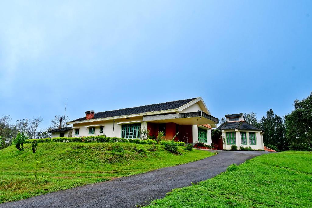a house on a hill with a road at Hill Top Homestay - Estate & Whole Place in Chikmagalūr