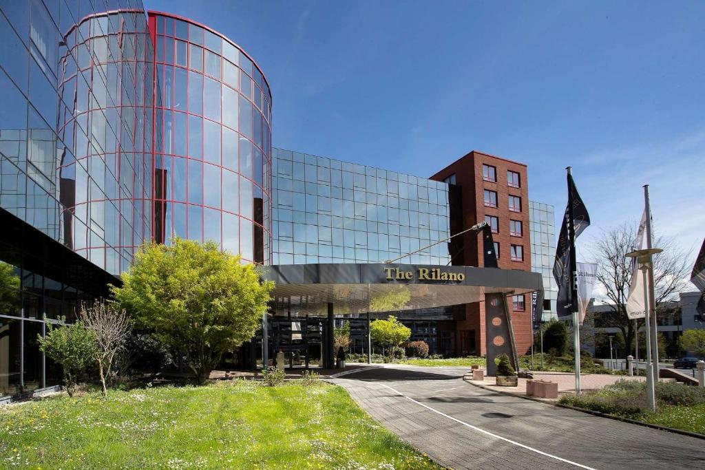 a glass building with a sign in front of it at elaya hotel frankfurt oberursel in Oberursel