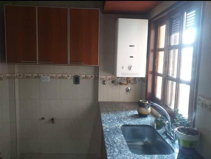 eine Küche mit einem Waschbecken und einem Fenster in der Unterkunft Tucuman Centro Departamento in San Miguel de Tucumán
